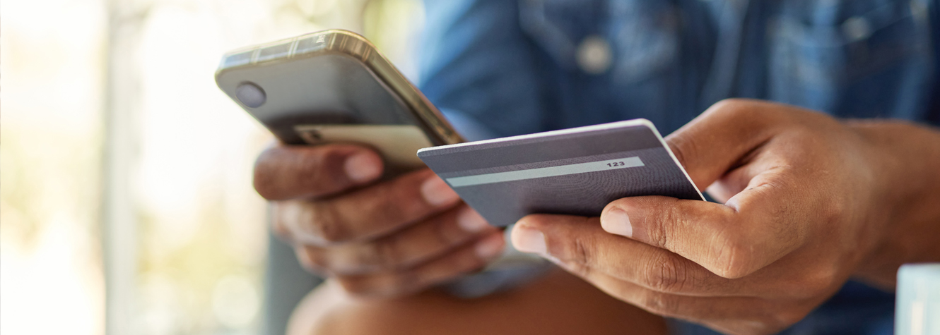 man with debit card and phone