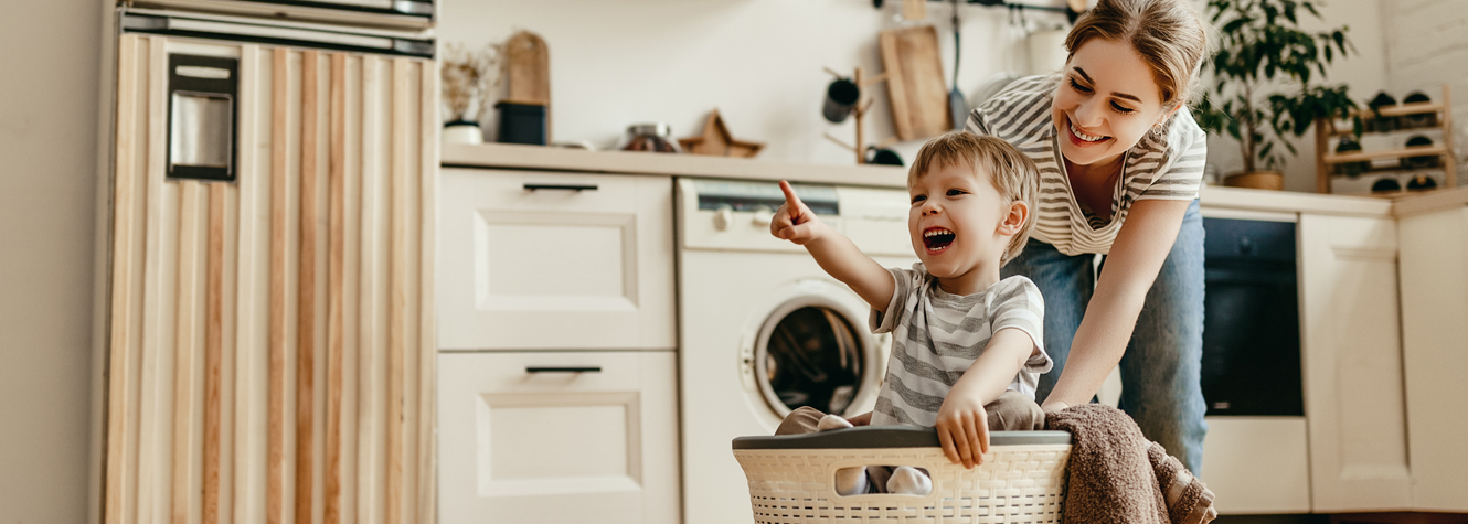 mom with son in laundry basket