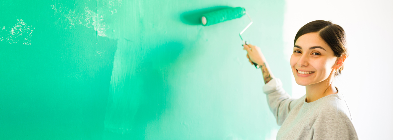 Hispanic woman painting wall