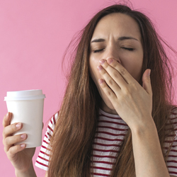teen girl yawning with coffee