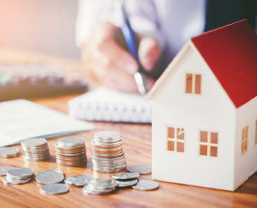 small house with coins on desk