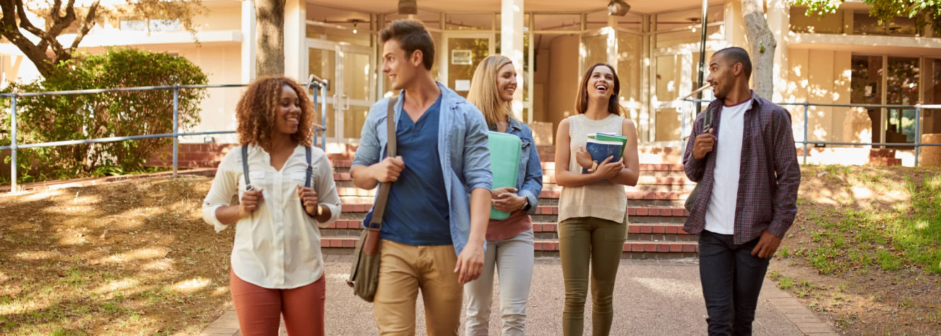 A diverse group of students walking on a college campus.