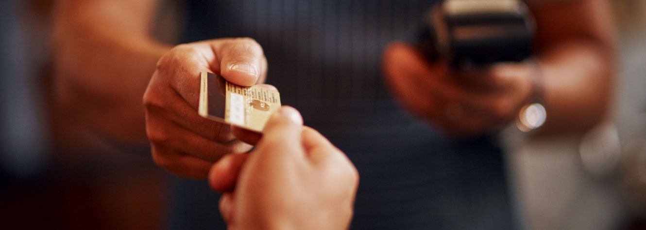 Close up of two people's hands exchanging a credit card.