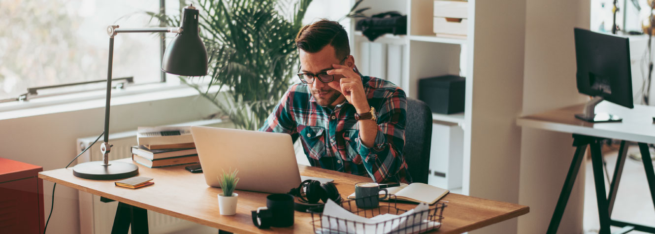 Man sitting at a desk using a laptop