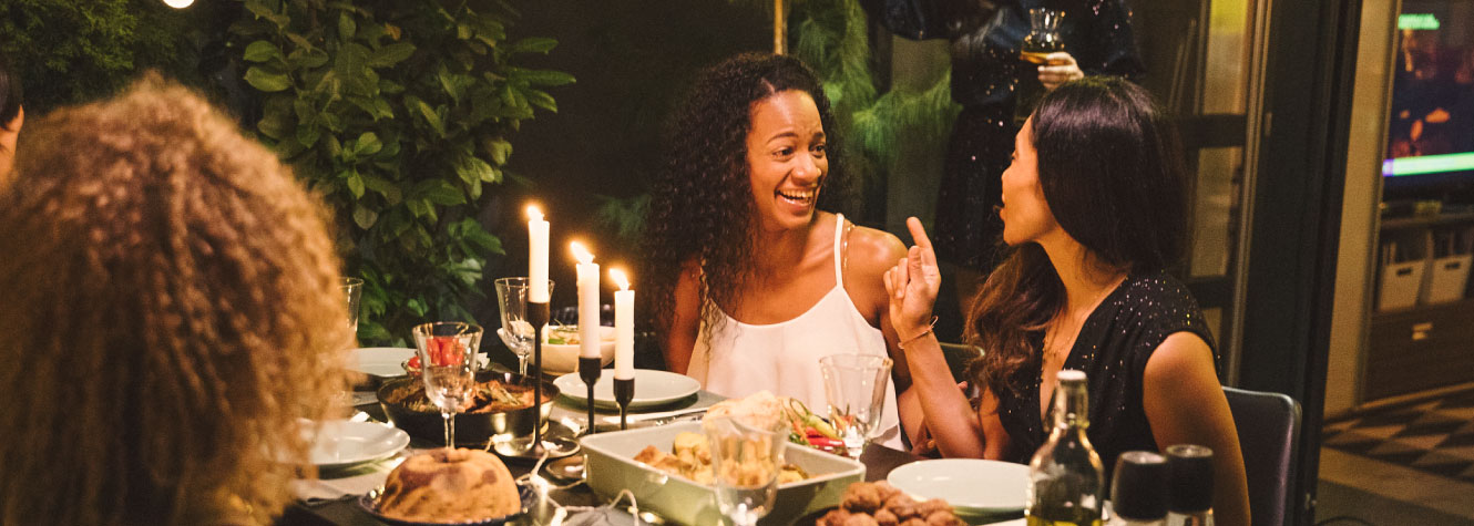 A family around a dinner table with food and candles.