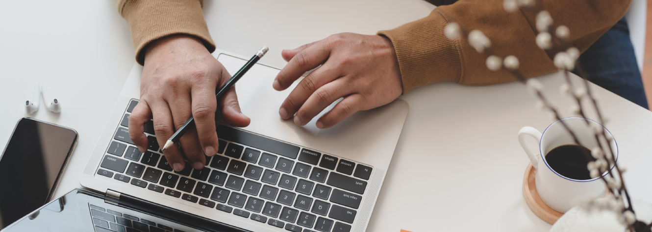 Close up of a person's hands using a laptop.