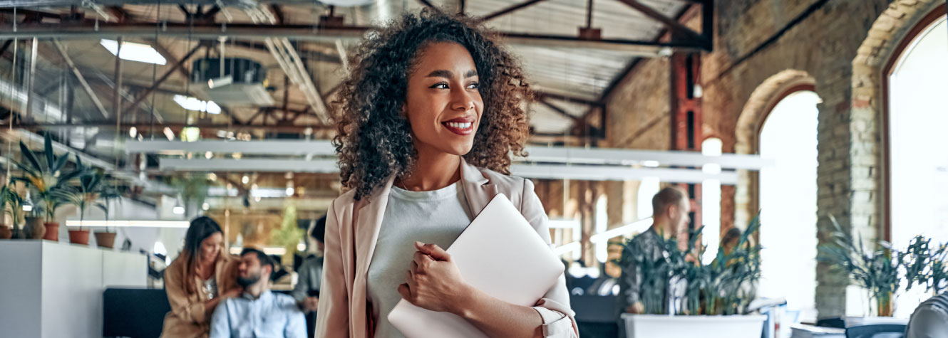 A businesswoman standing in an office looking in the distance.